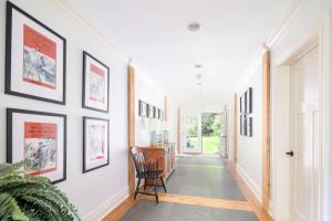 a hallway with black and white pictures on the walls at Summerset Villa by Rove - Family Home with Pool & Hot Tub in Bridgehampton
