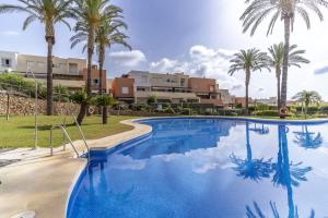 ein großer Swimmingpool mit Palmen im Hintergrund in der Unterkunft Brisa del Valle Casa con Jardín Piscina Parking in Vera