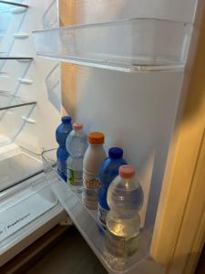 a refrigerator filled with blue and white bottles on a shelf at Larocca Tourist Home 5 Bassano in Bassano del Grappa