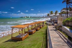 a row of beds on the beach next to the ocean at Serhs Natal Grand Hotel & Resort in Natal