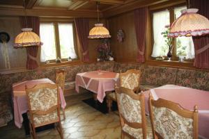 una sala da pranzo con due tavoli, sedie e finestre di Gästehaus Sylvia a Biberwier