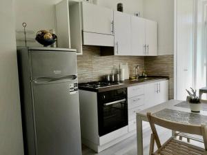 a kitchen with a stainless steel refrigerator and white cabinets at Julia affittacamere in Trieste
