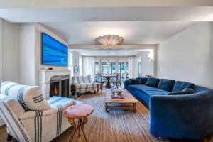 a living room with a blue couch and chairs at Wells Villa by Rove Travel - Family Home with Pool & Sauna in Amagansett