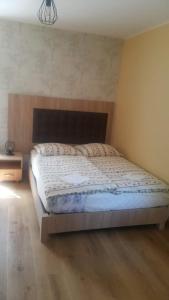 een slaapkamer met een groot bed met een houten hoofdeinde bij Stacja Roman in Karpacz