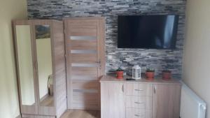 een woonkamer met een tv aan een bakstenen muur bij Stacja Roman in Karpacz