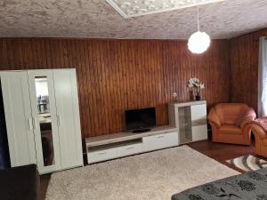 哈卡尼Lilaakác Vendégház的客厅墙上有一台平板电视