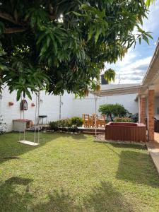 a yard with a bench and a tree at Casa Vacacional con Jaccuzi privado- Centro de Anapoima in Anapoima
