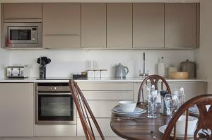a kitchen with a table with chairs and a microwave at Skye Eyrie in Staffin +33 photos