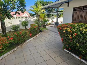a walkway next to a house with flowers at Les 2 Chambres Wassai in Rémiré