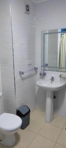 a white bathroom with a toilet and a sink at PISO En NADOR MARRUECOS in Nador
