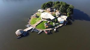 an island in the water with a group of tents at Pousada Pinima Xperience in Goianesia do Para