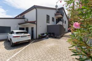 una macchina bianca parcheggiata di fronte a una casa di Apartman Diamond Pula a Pola (Pula)