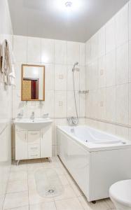 a white bathroom with a tub and a sink at Frant Hotel in Volgograd