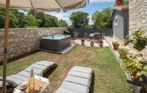 a backyard with a hot tub in a yard at Stunning Home In Umag With Wifi in Umag