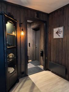 a hallway with wood paneled walls and an open door at Norefjell Ski in - Ski out in Noresund +19 photos