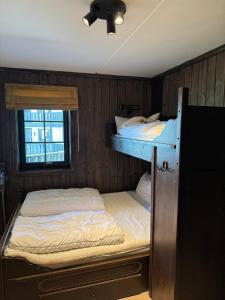 two bunk beds in a room with a window at Norefjell Ski in - Ski out in Noresund