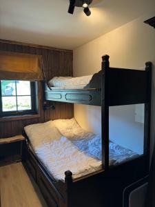 two bunk beds in a room with a ceiling fan at Norefjell Ski in - Ski out in Noresund