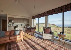 a living room with a couch and chairs and a table at Skye Eyrie in Staffin