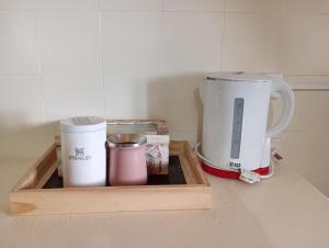 a tray with two cups and a coffee maker on a counter at Hogar en el corazón de Tilcara in Tilcara