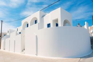 a white building with a person standing on top of it at SantoNight Luxury Villas in Santorini