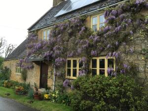 a house with purple flowers on the side of it at The Hidcote Hideaway, Cotswolds in Mickleton
