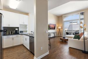 a kitchen with white cabinets and a living room at Zircon Zen - Quiet retreat 2BR Pool, Jacuzzi Marina in Los Angeles