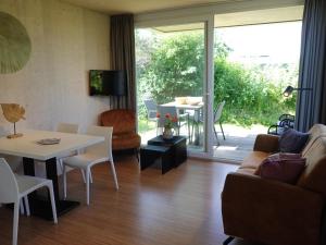 a living room with a couch and a table at Design Cabin Sint Maartenszee in Sint Maartensvlotbrug