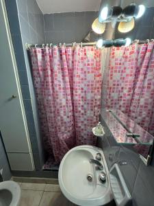 a bathroom with a sink and a shower curtain at Departamento céntrico in Mar del Plata
