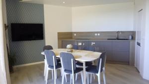 a dining room with a table and blue chairs at Valcros Paradis in La Londe-les-Maures