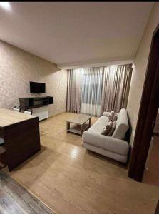 a living room with a couch and a tv at bakuriani in Itʼkhvisi