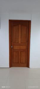 a wooden door in a room with a white wall at Casa isyosandra 1 in Acapulco +3 photos