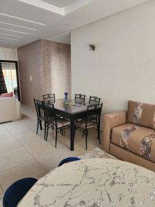 a living room with a table and chairs and a couch at Anis Home in Agadir