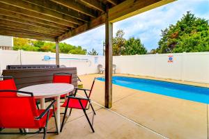 un patio avec une table et des chaises à côté d'une piscine dans l'établissement 5175 - Beach Bliss, à Croatan Shores