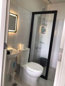 a bathroom with a toilet and a shower and a sink at Juvycondo in Davao City