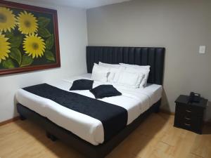 a bedroom with a large bed with yellow flowers on the wall at Hotel Santiago Plaza in Bogotá