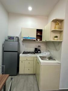 eine kleine Küche mit Kühlschrank und Spüle in der Unterkunft Tu escapada perfecta in Mazatlán