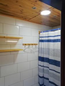 W łazience znajduje się prysznic z niebiesko-białą zasłoną prysznicową. w obiekcie Casa ecologica, autosuficiente en Lomo Blanco, dentro de una casa rodeada de naturaleza w mieście San Juan de la Rambla