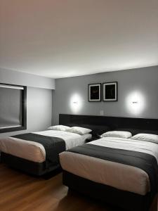 pokój hotelowy z 2 łóżkami i 2 zdjęciami na ścianie w obiekcie Nights Inn w mieście One Hundred Mile House +22 zdjęcia