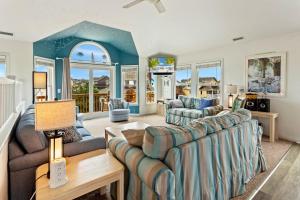 a living room with two couches and a table at 6170 - Poolside Paradise in Nags Head