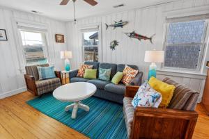 a living room with a couch and a table at 5050 - Sea Haven in Kill Devil Hills