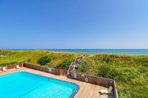 a swimming pool on a deck next to the beach at AV2D - By The Sea in Nags Head
