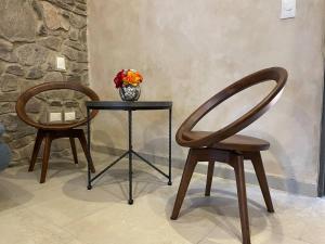 two chairs and a table with a vase of flowers at Acogedor espacio LAppuntamento in Santeagueda