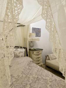 a bedroom with a canopy bed and a dresser at Hébergement cycladique - près de Panormos in Mykonos
