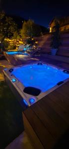a jacuzzi tub in a backyard at night at Papillon 05 - Wellness - 6 Pers - Sauna - Jacuzzi - Yoga - Petanque - Parking in Briançon
