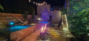 a backyard with a swimming pool at night at Papillon 05 - Wellness - 6 Pers - Sauna - Jacuzzi - Yoga - Petanque - Parking in Briançon +27 photos