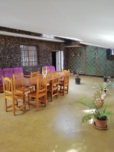 długi drewniany stół i krzesła w pokoju w obiekcie Casa ecologica, autosuficiente en Lomo Blanco, dentro de una casa rodeada de naturaleza w mieście San Juan de la Rambla