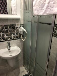 a bathroom with a shower with a sink and a shower at GOLD SARAY PANSİYOn in Saray +6 photos