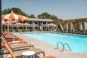 a pool at a hotel with chairs and umbrellas at UNCOMMONER HOTEL by Reverie Boutique Collection in West Yarmouth