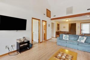 a living room with a blue couch and a flat screen tv at 1714 - Destiny in Poplar Branch