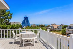 a table with a blue umbrella on a deck at 2035 - Irish C in Sea Ridge